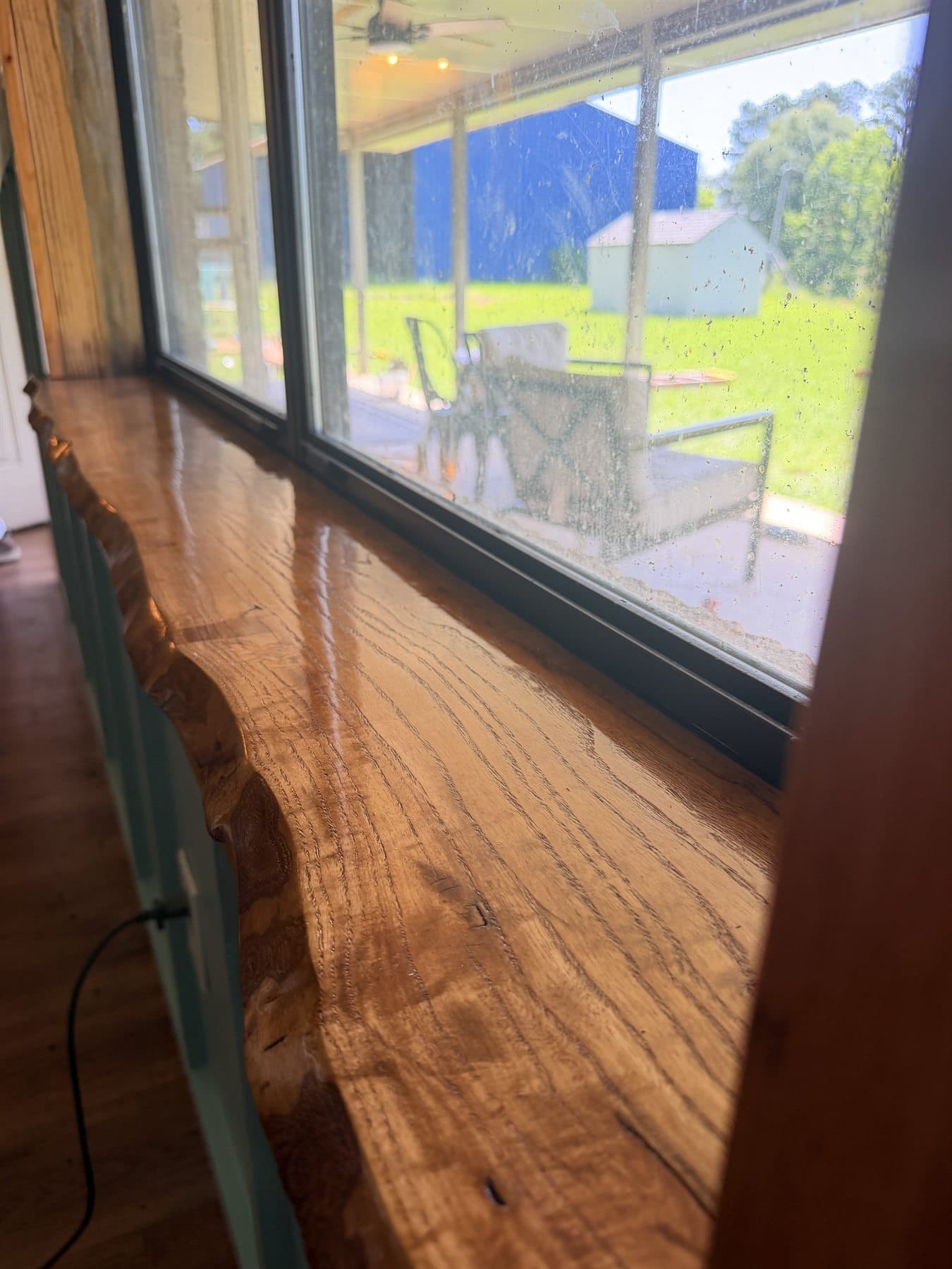 Long view of a custom live edge windowsill beside a residential window