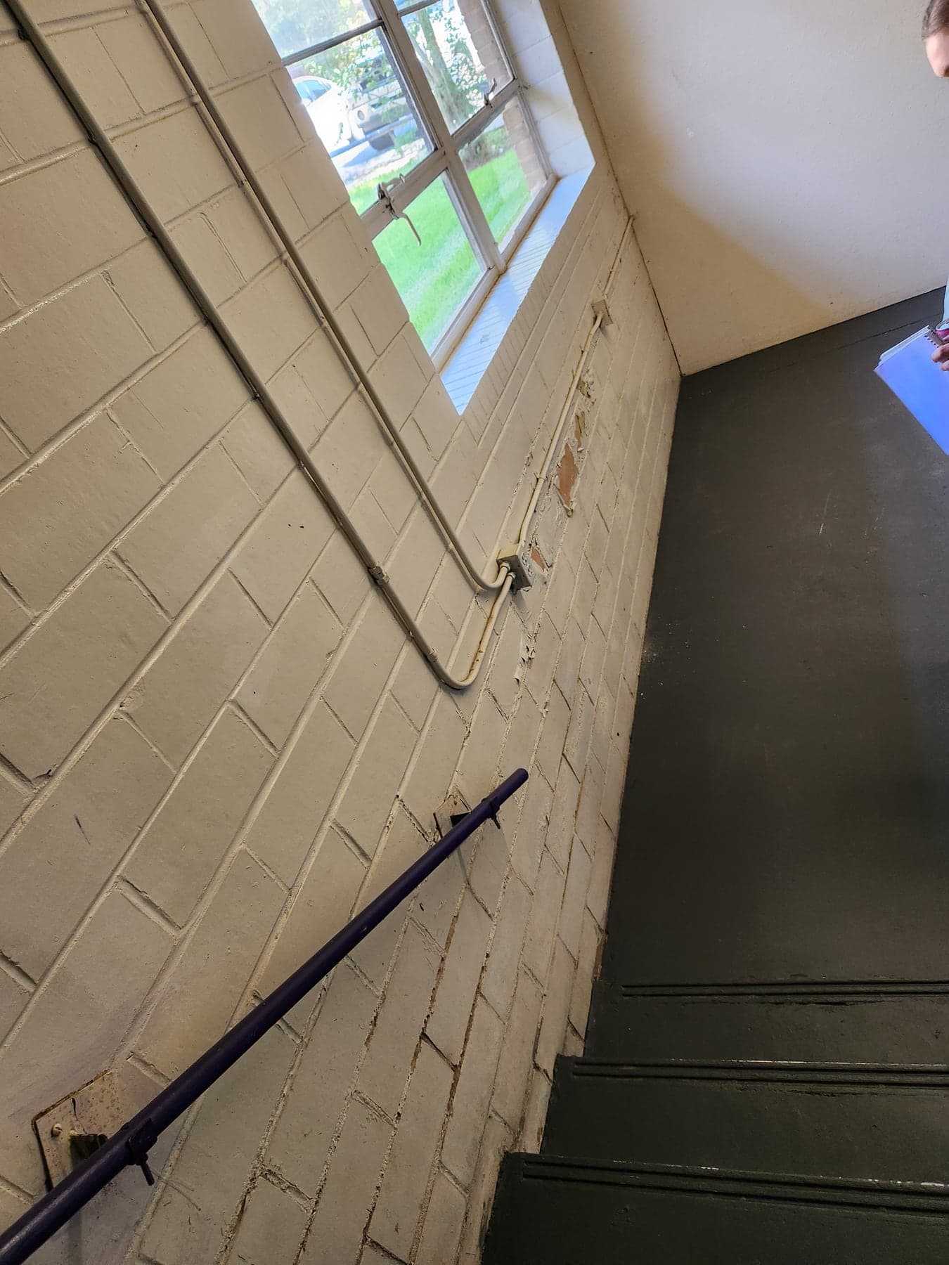 Peeling coating on an interior below-grade school retaining wall before Alpha restoration