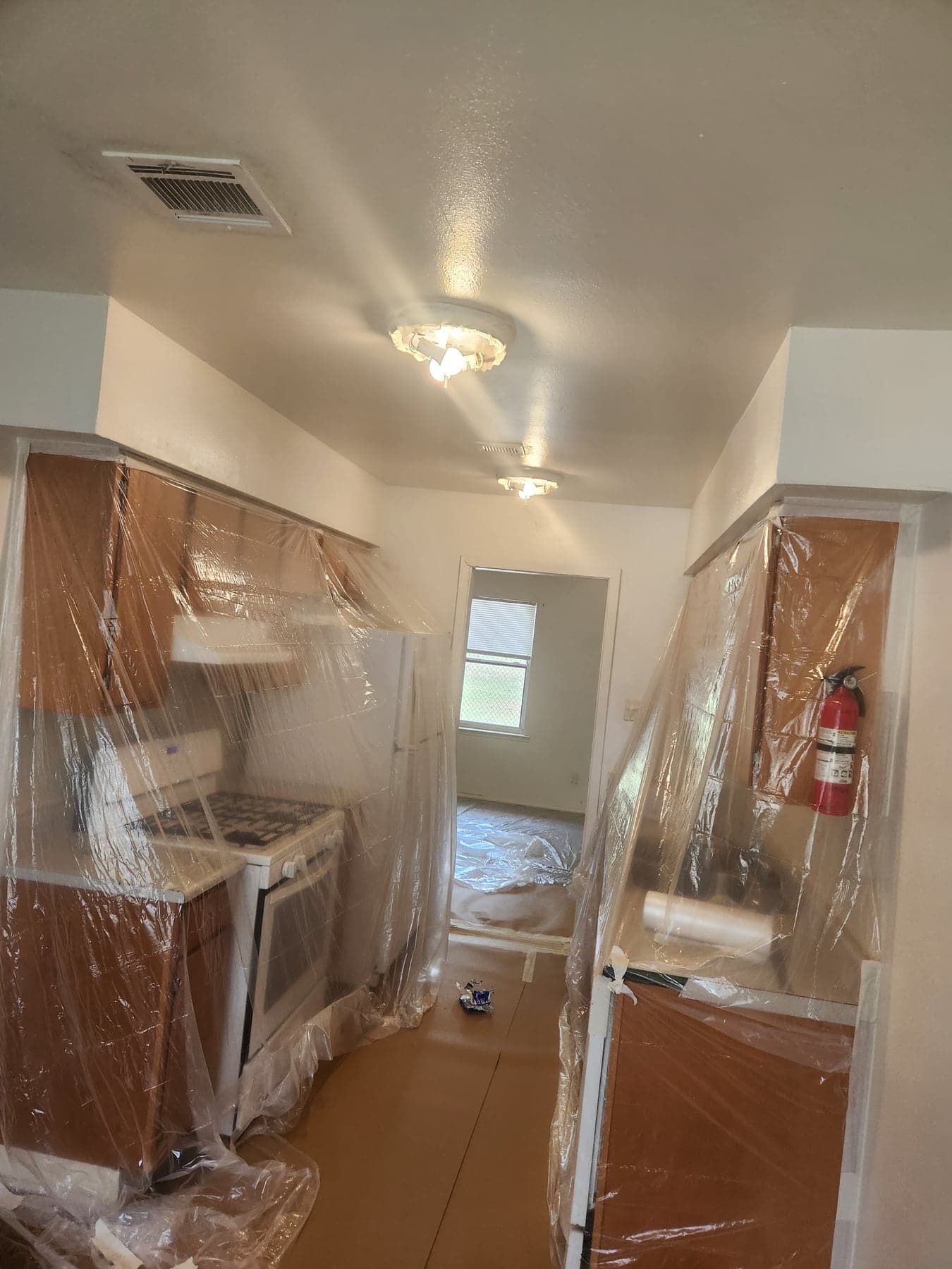 Kitchen cabinets masked and protected before property turn paint spraying